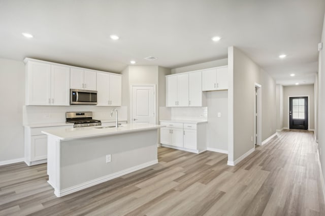 kitchen featuring a kitchen island with sink, sink, white cabinetry, and stainless steel appliances