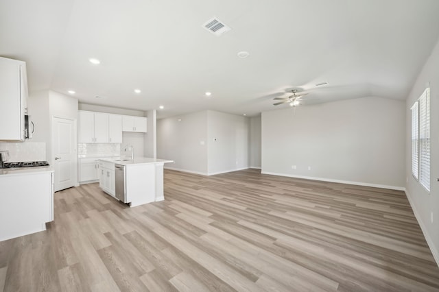 kitchen featuring light hardwood / wood-style flooring, a center island with sink, dishwasher, decorative backsplash, and white cabinets