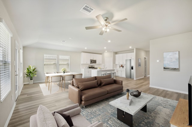 living room featuring ceiling fan and light hardwood / wood-style flooring