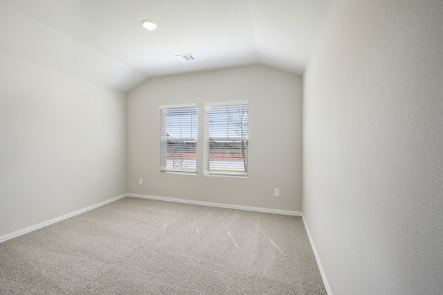 unfurnished room with lofted ceiling and carpet flooring