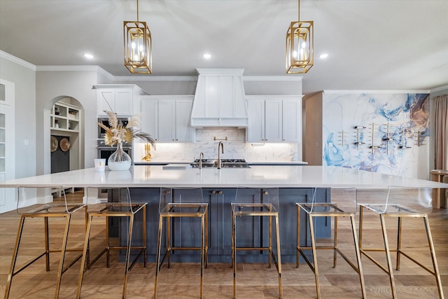 kitchen featuring a spacious island, custom exhaust hood, and white cabinets