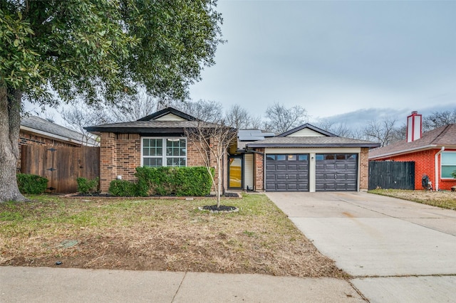 ranch-style home with a garage and a front lawn