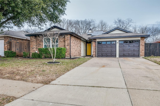 single story home featuring a garage and solar panels