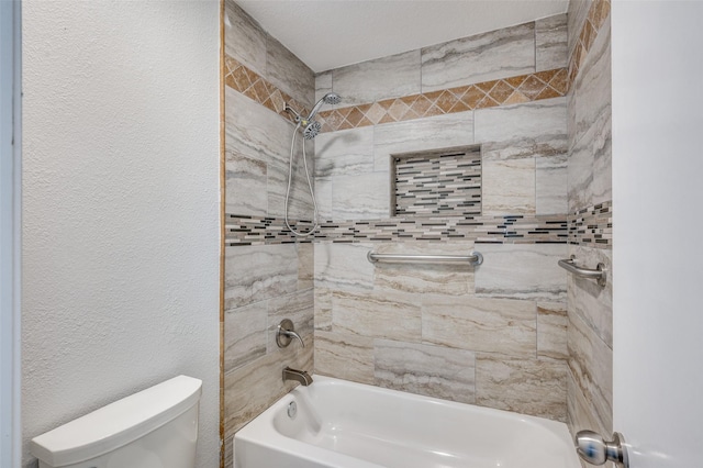 bathroom featuring tiled shower / bath and toilet