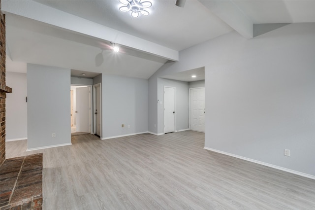 basement with a brick fireplace and light hardwood / wood-style flooring