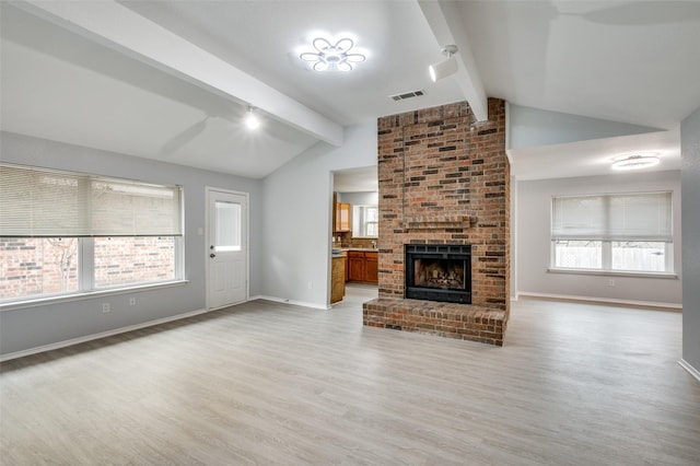 unfurnished living room featuring a fireplace, light wood-type flooring, and vaulted ceiling with beams