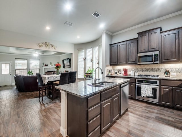 kitchen featuring a sink, light stone countertops, visible vents, and stainless steel appliances