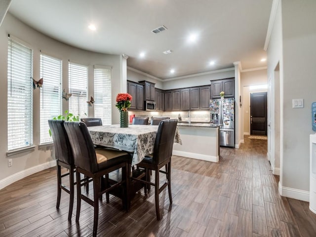 dining area featuring visible vents, plenty of natural light, baseboards, and wood finished floors