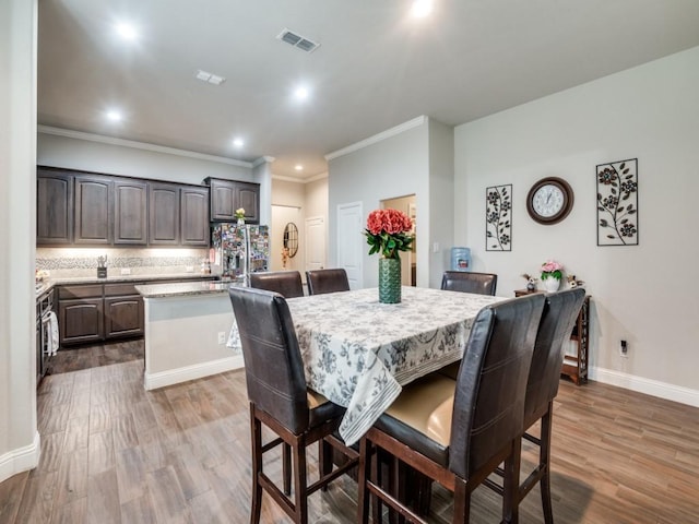 dining room featuring ornamental molding, visible vents, dark wood-style flooring, and baseboards