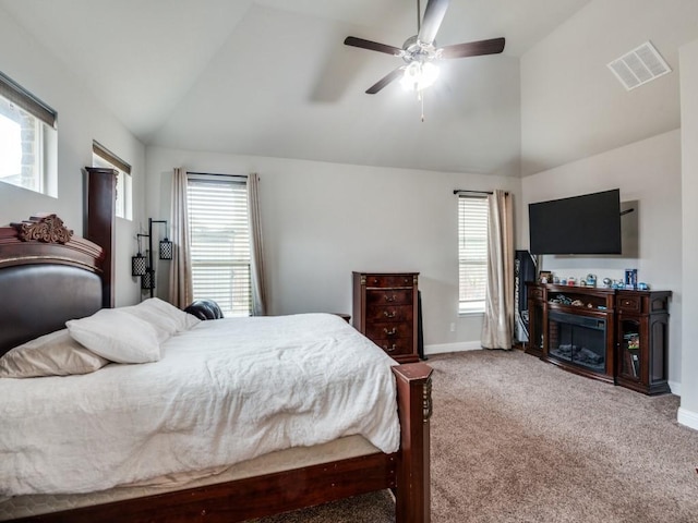 carpeted bedroom featuring lofted ceiling, multiple windows, baseboards, and visible vents