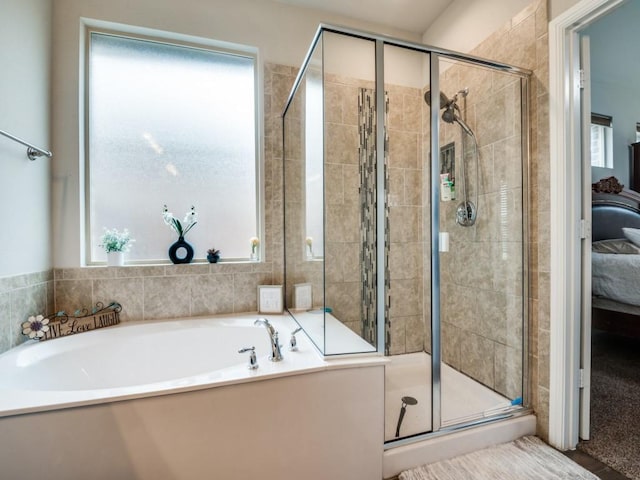 bathroom with a stall shower, ensuite bath, and a garden tub