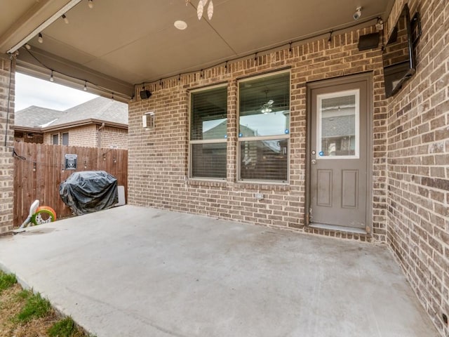 view of patio with area for grilling and fence