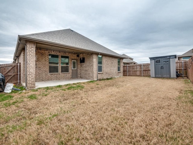 rear view of property with a storage shed, a patio, a fenced backyard, and brick siding