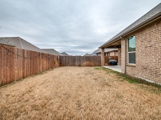 view of yard featuring a patio area and a fenced backyard