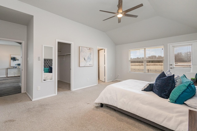 bedroom featuring lofted ceiling, a spacious closet, light carpet, and ceiling fan