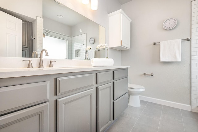 bathroom with vanity, toilet, tile patterned flooring, and a tile shower