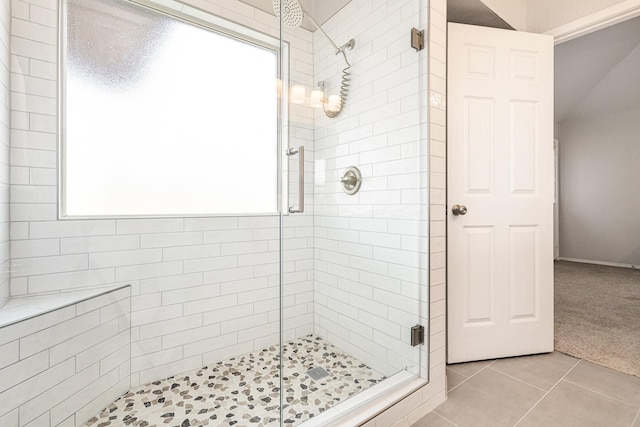 bathroom with a shower with door and tile patterned flooring