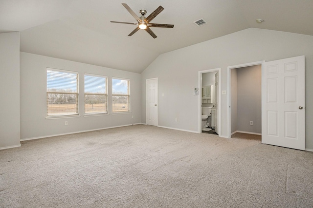 interior space featuring light carpet, ensuite bath, vaulted ceiling, and ceiling fan