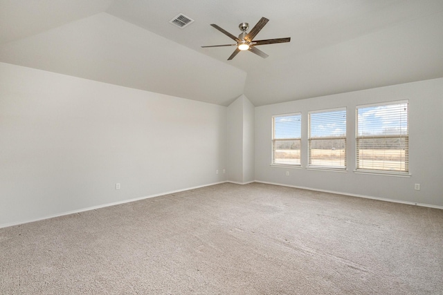 spare room featuring vaulted ceiling, carpet flooring, and ceiling fan