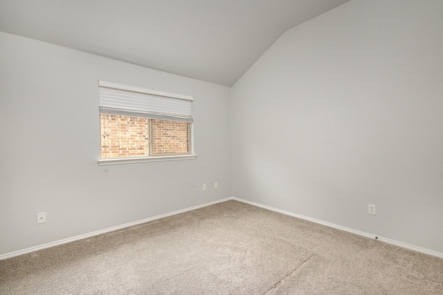 carpeted spare room with lofted ceiling