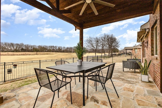 view of patio / terrace featuring ceiling fan and a rural view