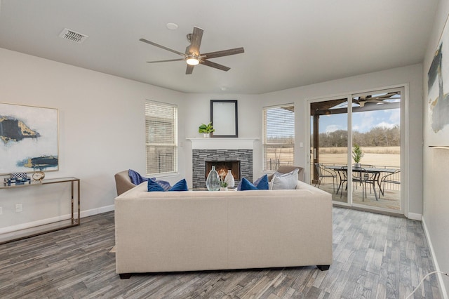 living room featuring hardwood / wood-style flooring, ceiling fan, and a fireplace