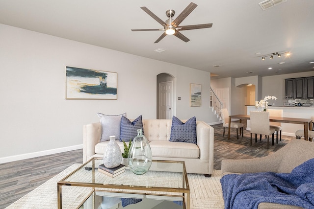 living room with wood-type flooring and ceiling fan