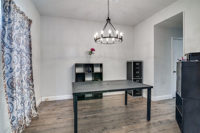 dining space featuring dark hardwood / wood-style floors and a chandelier