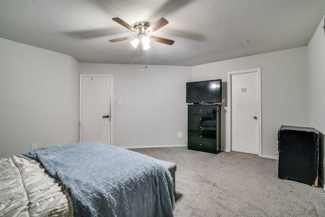 carpeted bedroom with ceiling fan and a textured ceiling