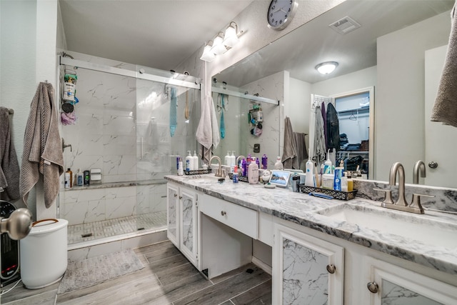 bathroom with vanity, hardwood / wood-style flooring, and a shower with shower door