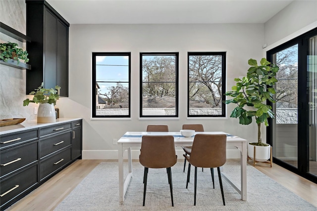 dining area with baseboards and light wood-type flooring