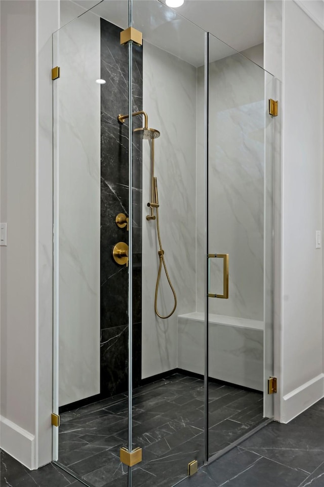 bathroom with a marble finish shower, baseboards, and marble finish floor