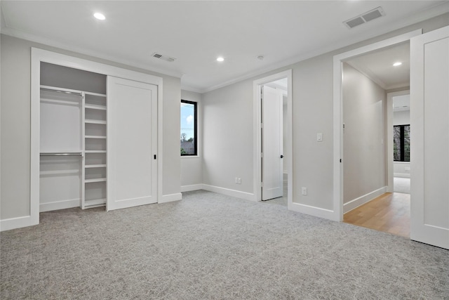 unfurnished bedroom featuring crown molding, baseboards, carpet, and visible vents