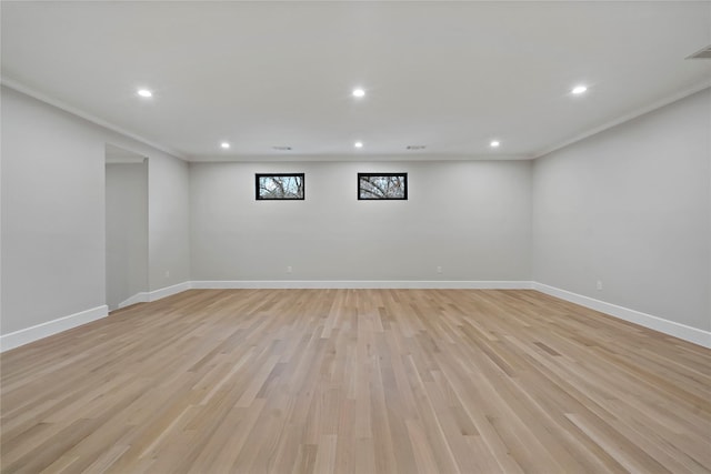 basement featuring crown molding and light hardwood / wood-style flooring