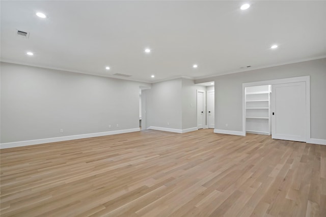 basement featuring ornamental molding and light hardwood / wood-style flooring