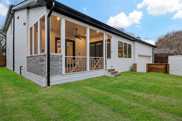 rear view of house featuring a sunroom, ceiling fan, and a lawn