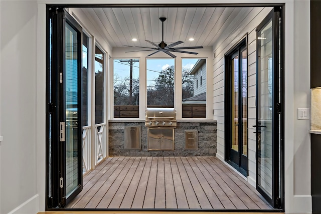 unfurnished sunroom with ceiling fan