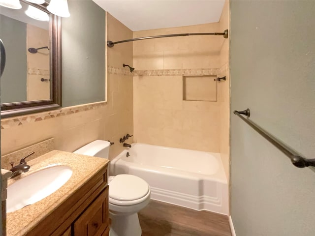 712 Brookfield Dr, Hurst, TX 76053 - bathroom with toilet, shower / washtub combination, wood finished floors, vanity, and tile walls