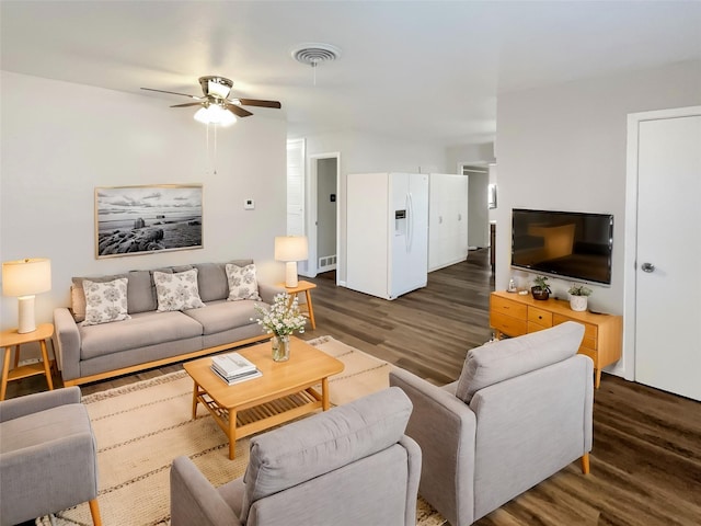 living room featuring ceiling fan and dark hardwood / wood-style flooring