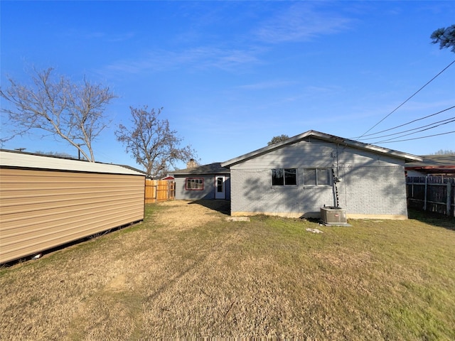 back of house featuring a yard and central AC unit