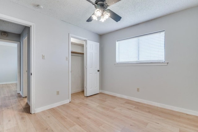 unfurnished bedroom featuring light wood-type flooring, a textured ceiling, and ceiling fan