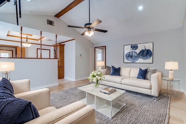 living room with ceiling fan, light hardwood / wood-style flooring, and vaulted ceiling with beams