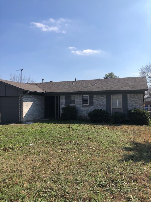 single story home with a garage and a front lawn