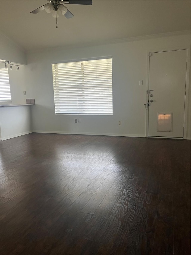 interior space with dark wood-style floors, a ceiling fan, baseboards, and crown molding