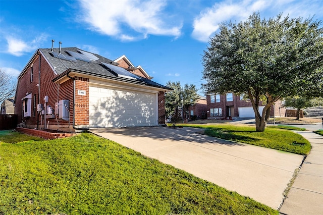 view of front facade featuring a garage, a front lawn, and solar panels