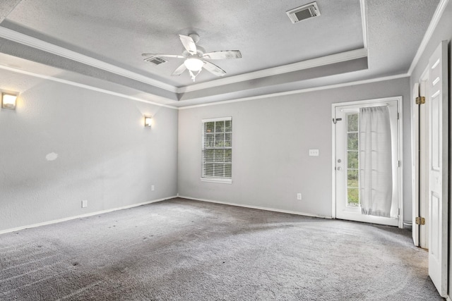 carpeted empty room with crown molding, a tray ceiling, plenty of natural light, and ceiling fan