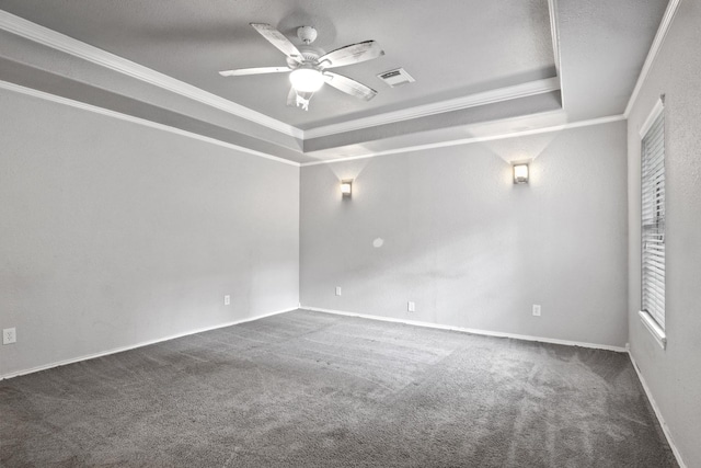 carpeted empty room with crown molding, ceiling fan, and a raised ceiling