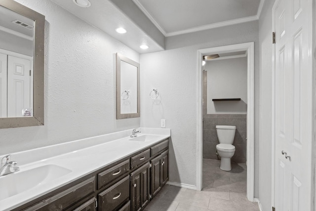 bathroom featuring toilet, tile walls, ornamental molding, vanity, and tile patterned flooring