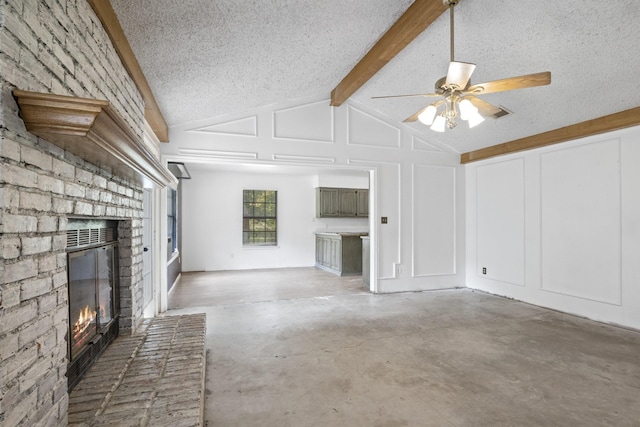 unfurnished living room with lofted ceiling with beams, concrete flooring, a brick fireplace, and a textured ceiling