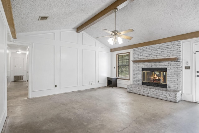 unfurnished living room with ceiling fan, a fireplace, lofted ceiling with beams, and a textured ceiling